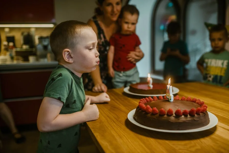 Young boy blowing out candles on a birthday cake