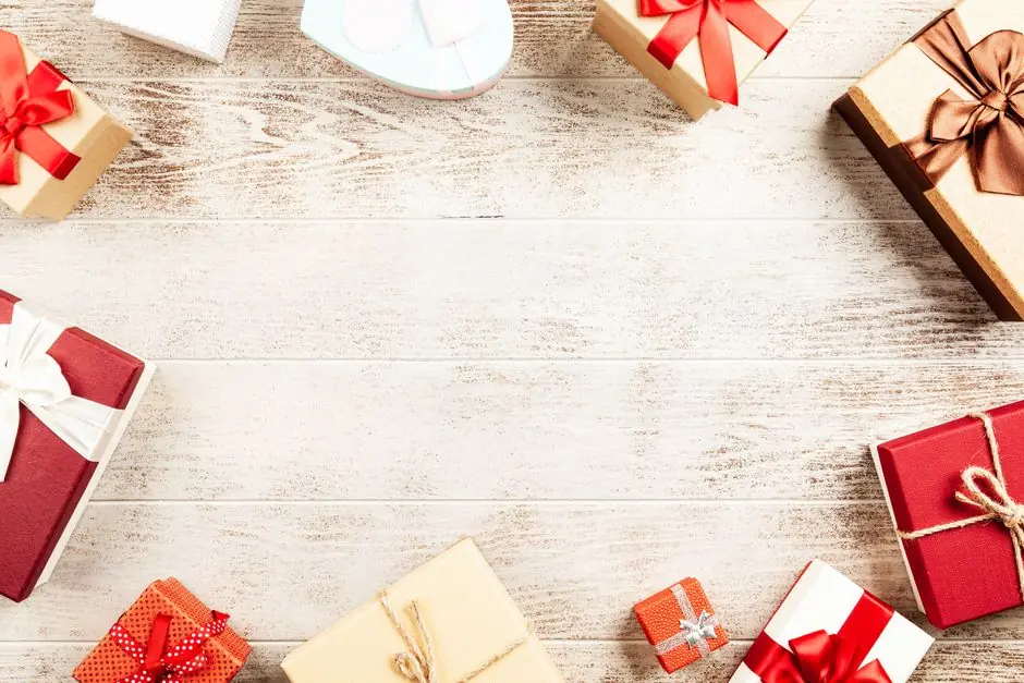 Wrapped gift boxes with red ribbons on a wooden table