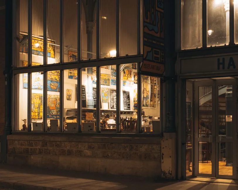 Lit restaurant windows on a city street at night