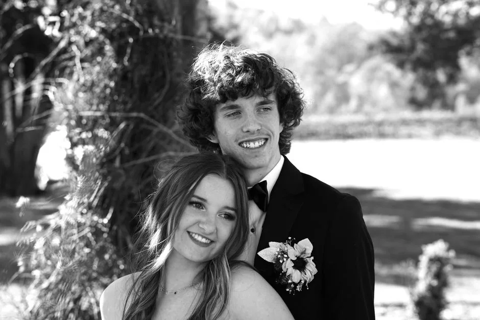 Couple in formal wear smiling, in black and white