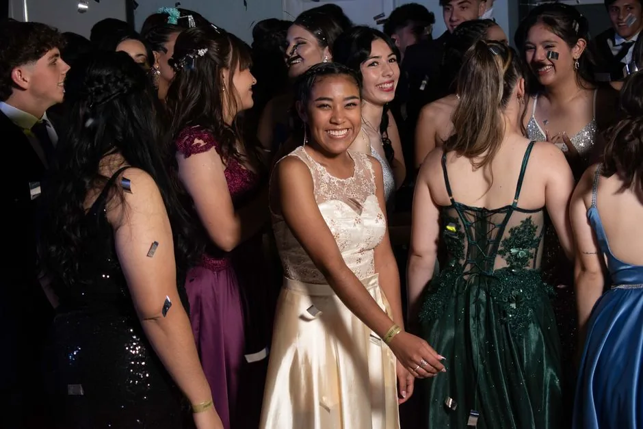 Students in prom dresses gathered on a dance floor