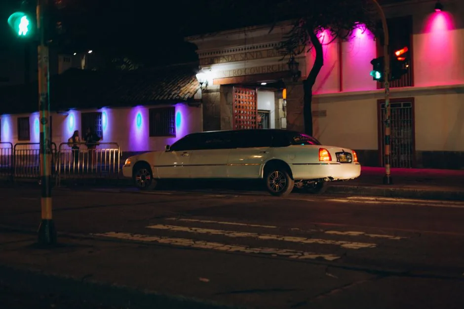 White stretch limousine parked on a street at night