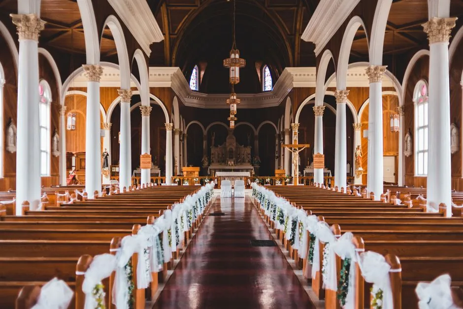 Church aisle lined with white flowers before a ceremony