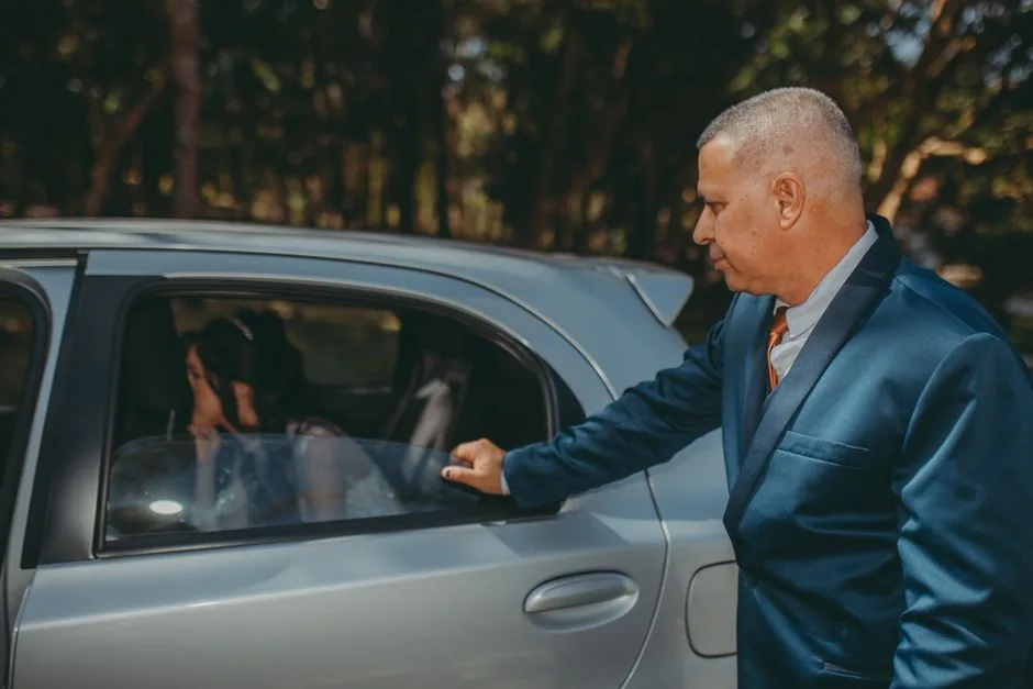 Bride and groom at the door of their wedding limousine