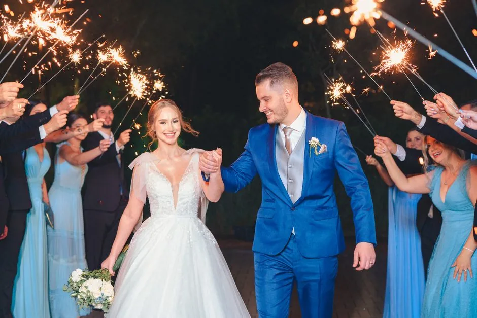 Bride and groom walking through a line of guests holding sparklers at night
