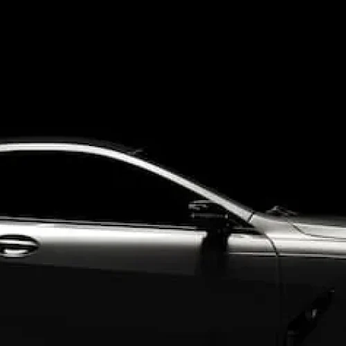 side view of a modern black limo with a dark black background