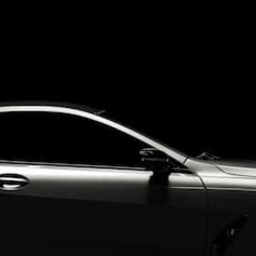 side view of a modern black limo with a dark black background